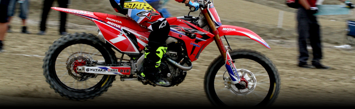 Person ridng a Honda® CRF®450R dirt bike racing in an off-road competition